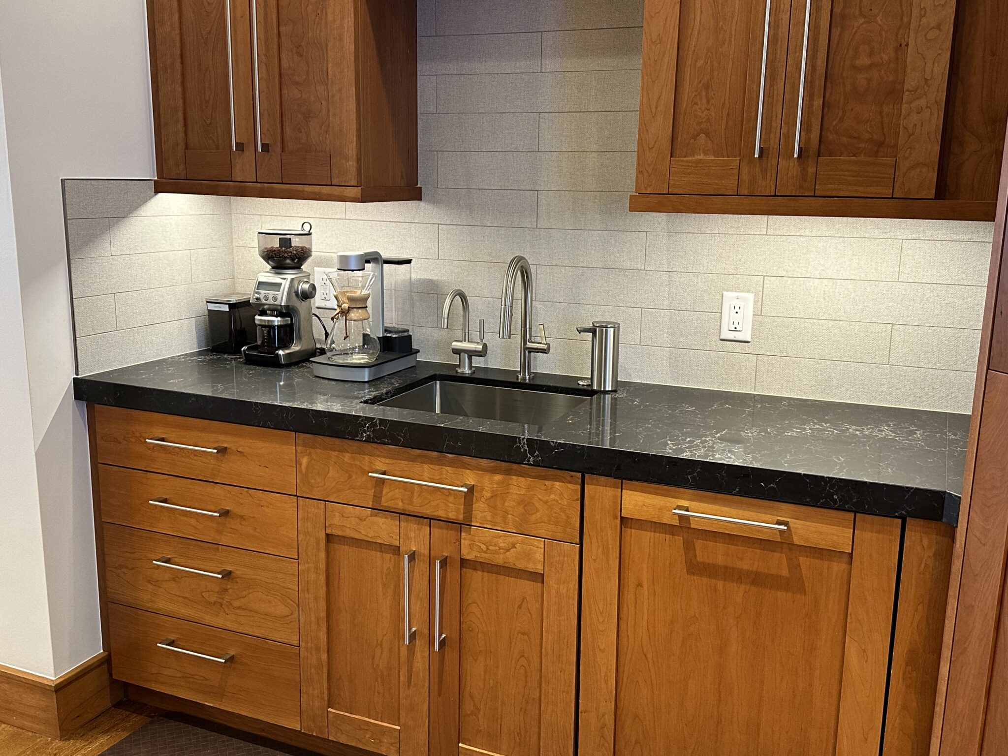 A Kitchen With a Black Countertop and Wooden Cabinets