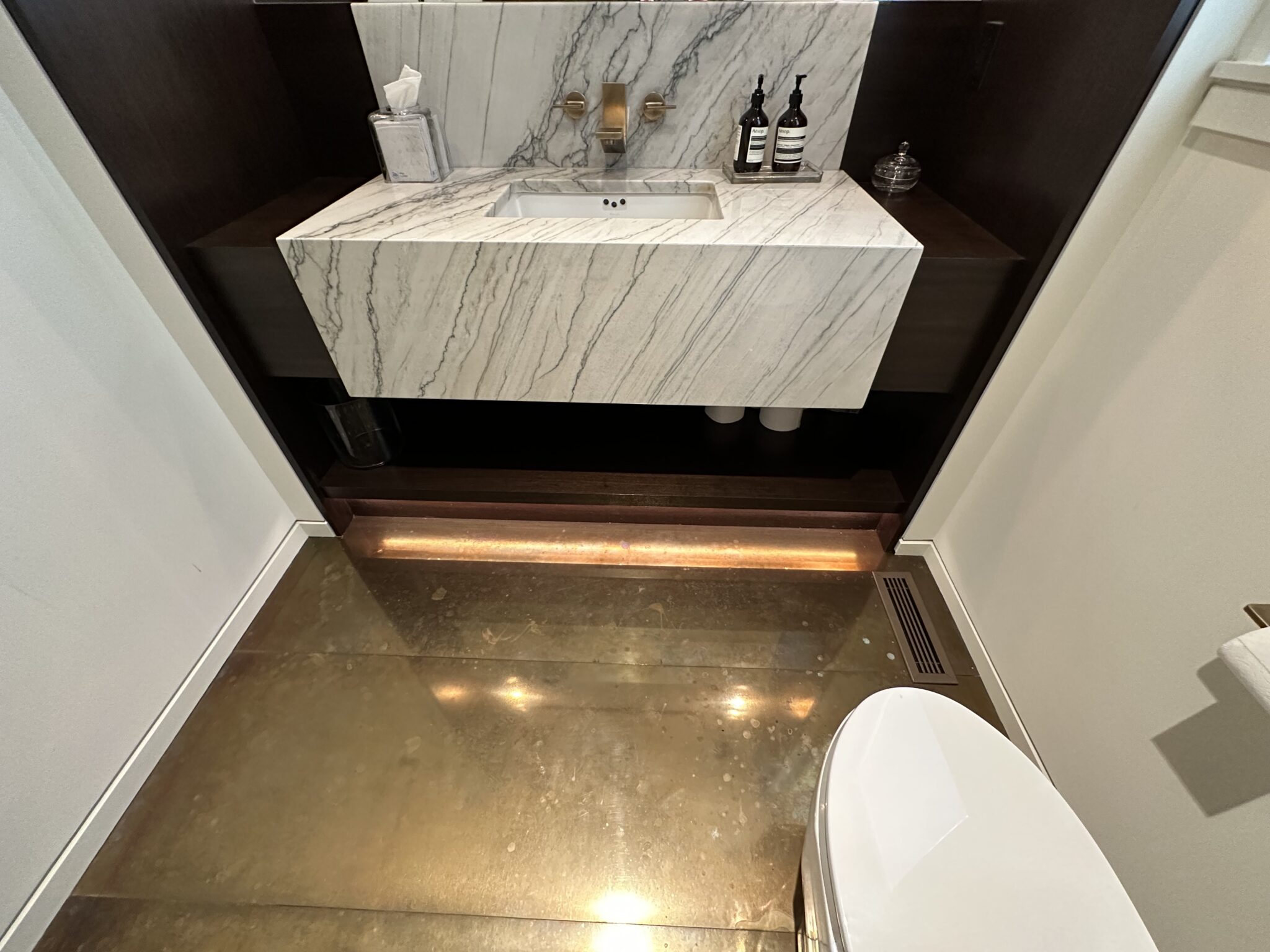 A Bathroom With a Marble Sink and Toilet